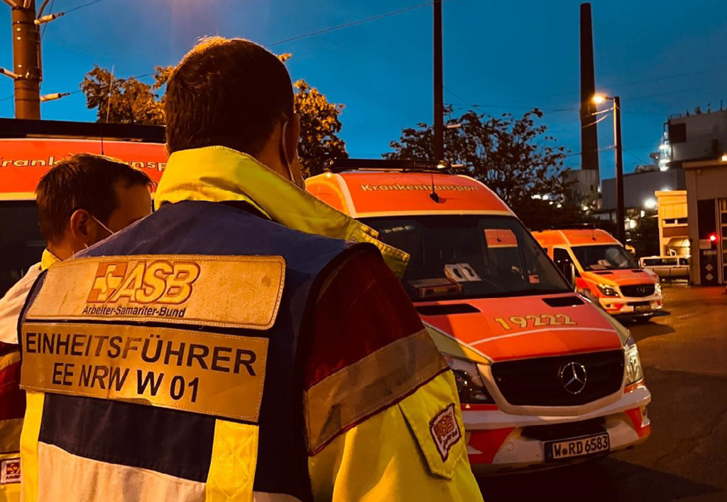 Beschnitt.png Ein Einheitsführer des ASB bei einer nächtlichen Besprechung mit einem Kollegen im Hochwassergebiet in NRW.