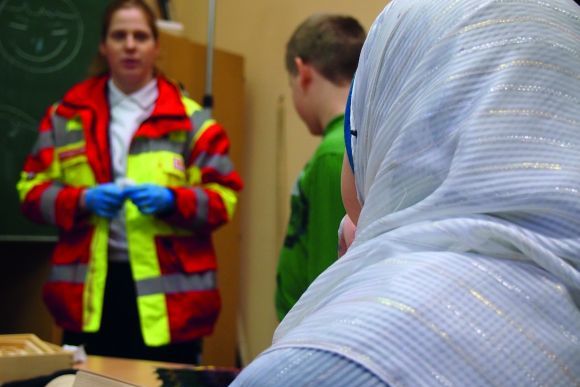 Rettungssanitäter mit zwei Jugendlichen.