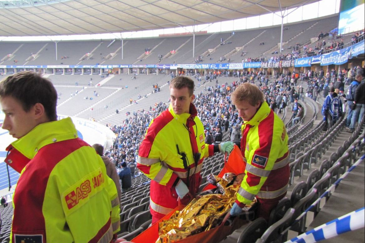 Ehrenamtliche Einsatzkräfte sichern die medizinische Versorgung während eines Fußballspiels.