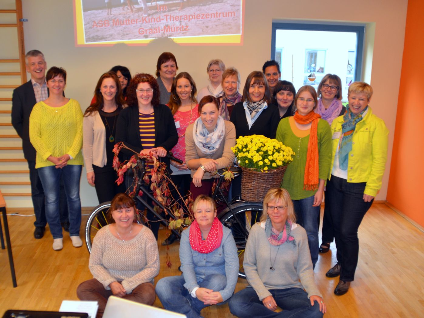 Eine Gruppe von Frauen und ein Mann lachen in die Kamera.