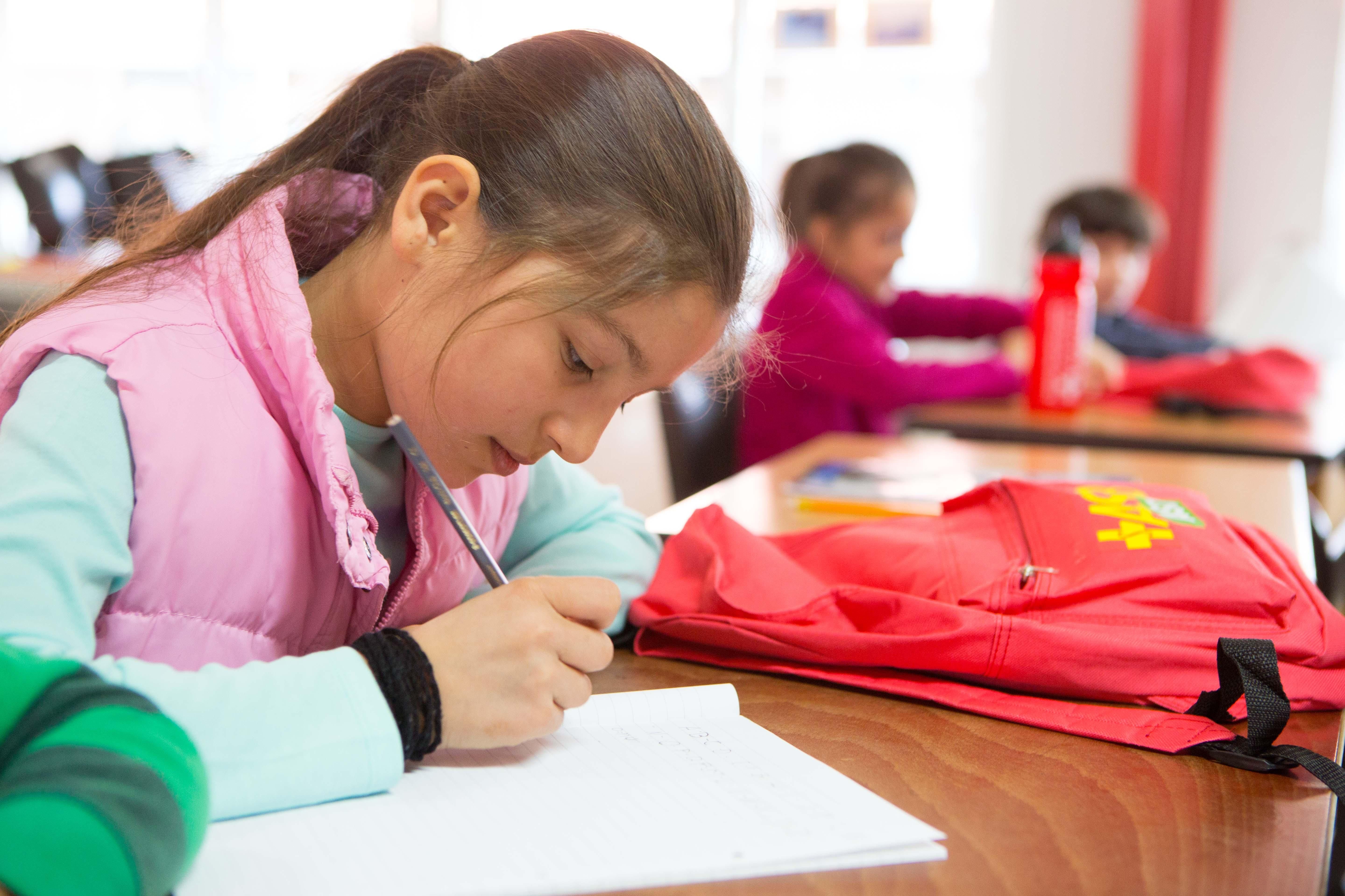 Ein Mädchen macht Hausaufgaben in einer Ganztagsschule