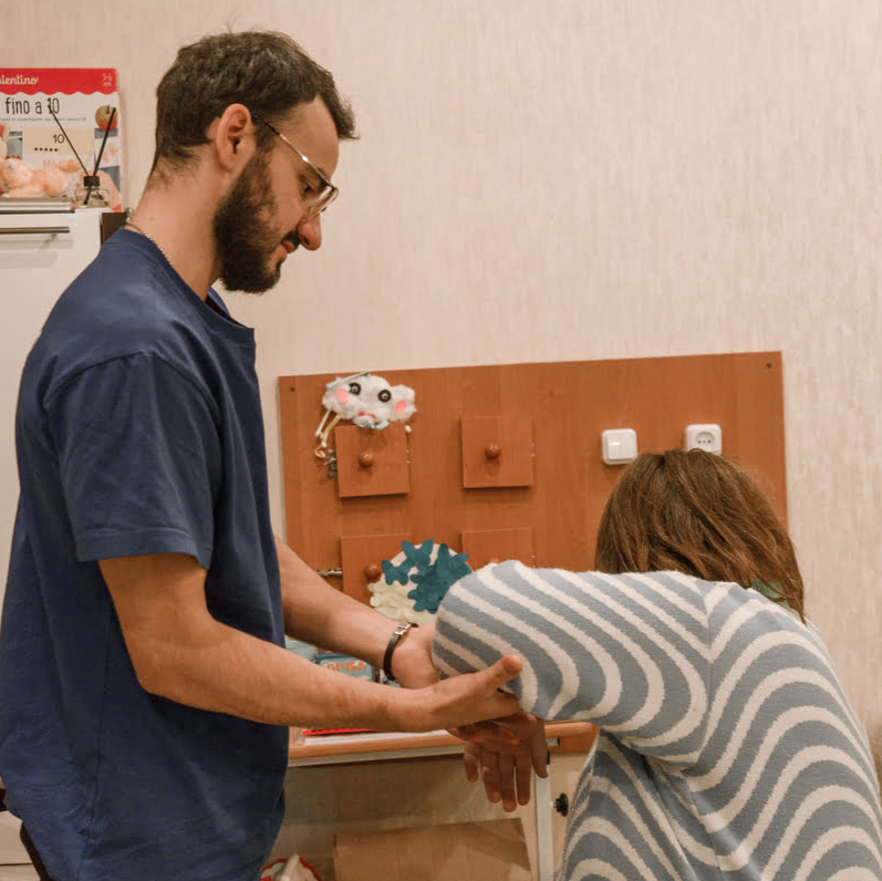 Ein Physiotherapeut bringt der Patientin Übungen bei, die sie selbstständig fortsetzen kann. 