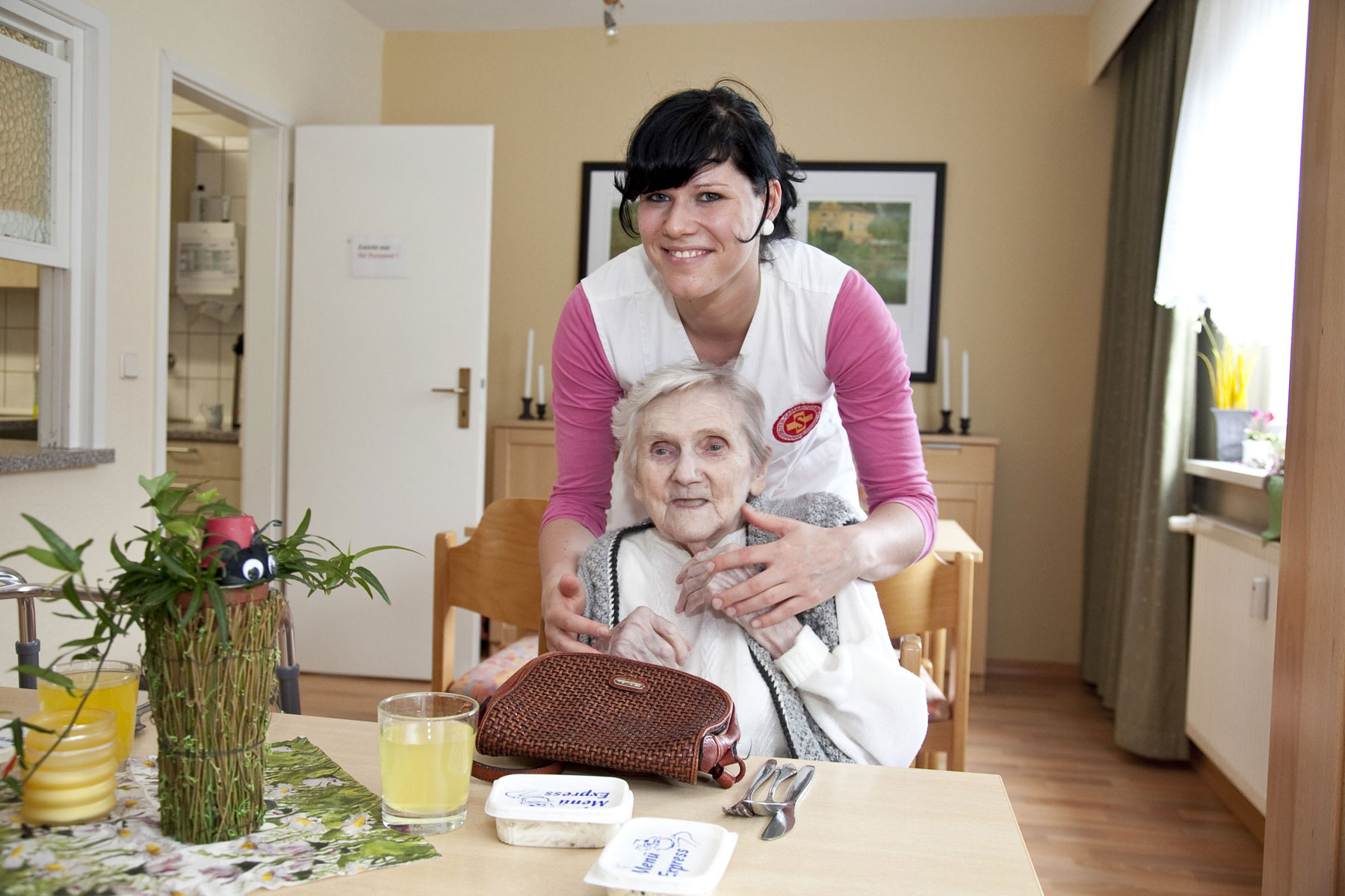 Eine ASB-Pflegerin kümmert sich um eine Seniorin