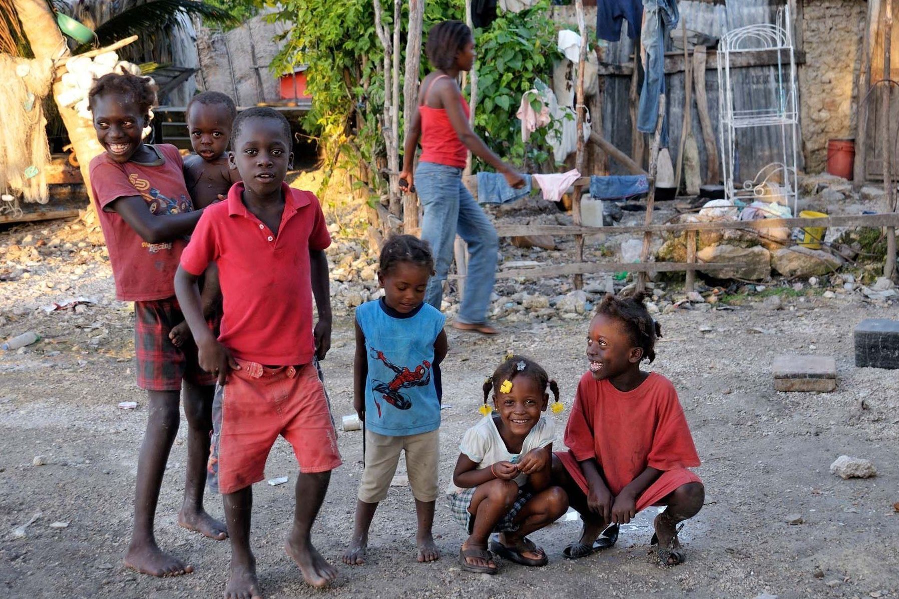 Kinder spielen vor den neuen Häusern in Haiti