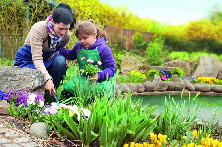 freiwilligenarbeit-junge-frau-mit-kind-im-garten-2.jpg