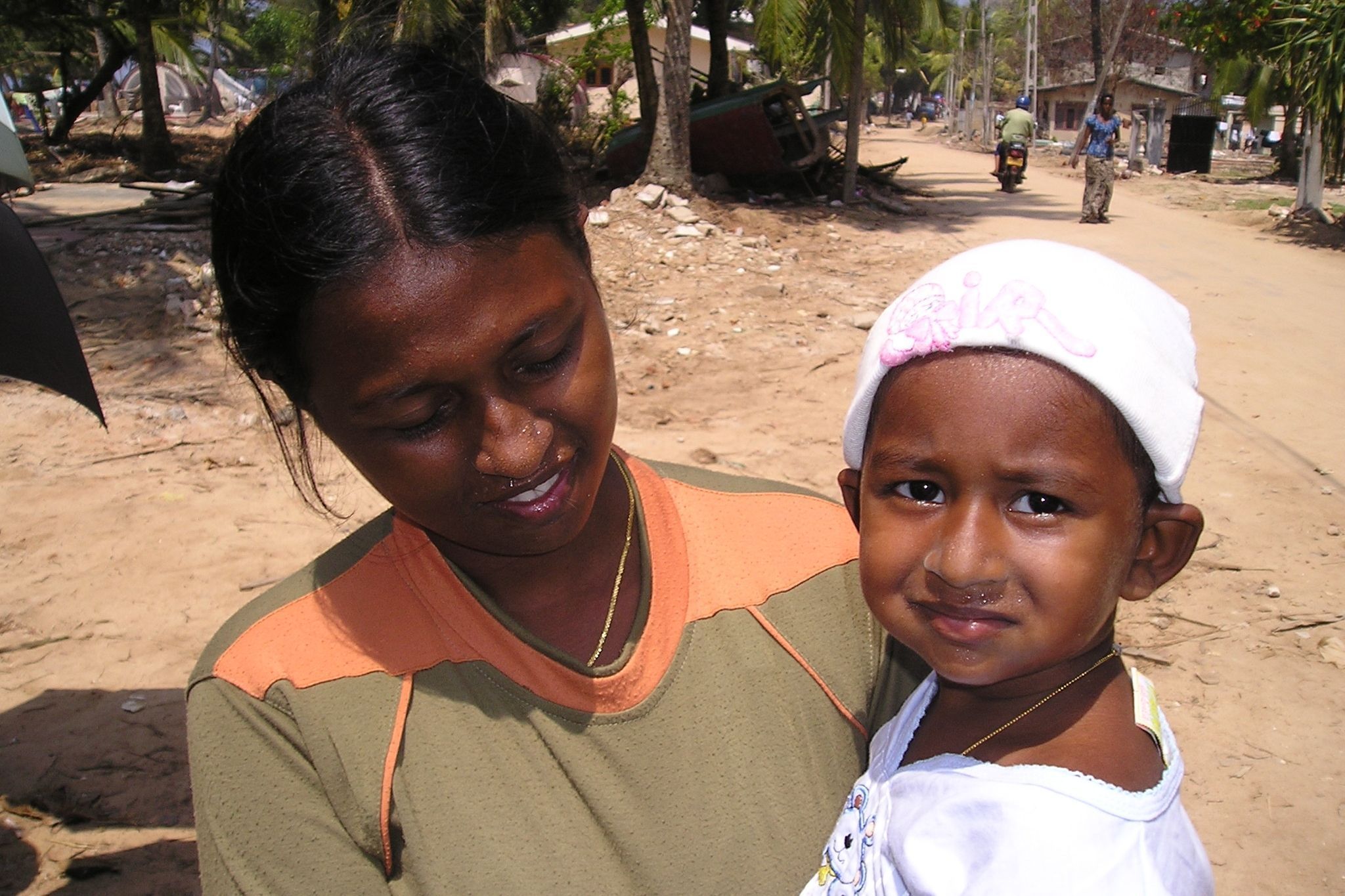 tsunami-sri-lanka-mutter-mit-kind Eine junge Mutter hält ein Baby auf dem Arm