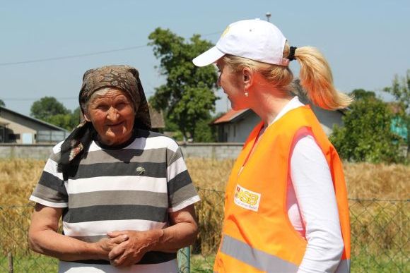 an ASB aid worker with a woman whose house had been destroyed by the floods