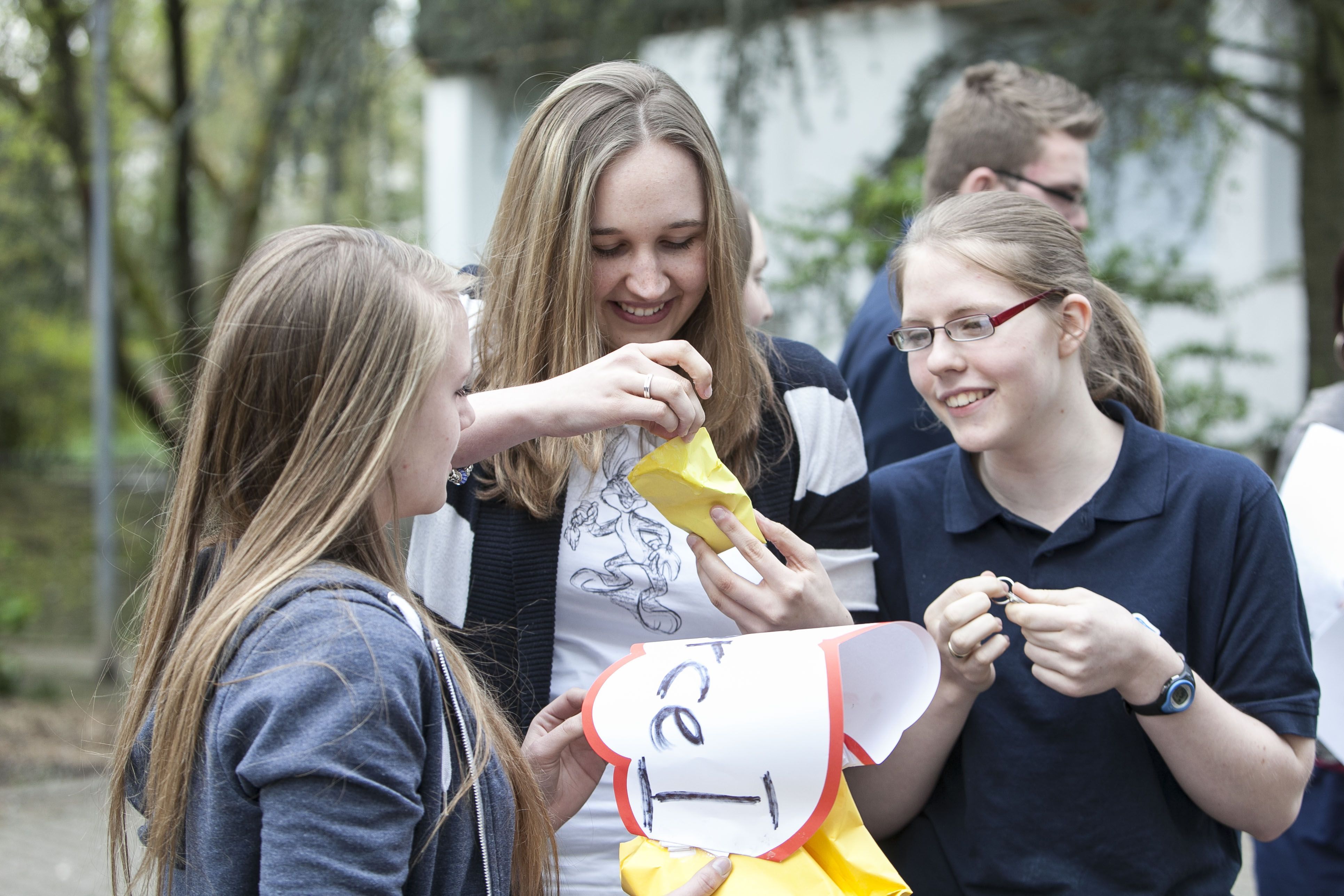 kind-und-jugendhilfe-freizeitangebote-drei-maedchen-mit-papiertueten-und-papier