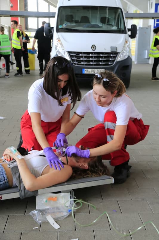 Zwei auszubildende Rettungssanitäterinnen üben die Transportvorbereitung