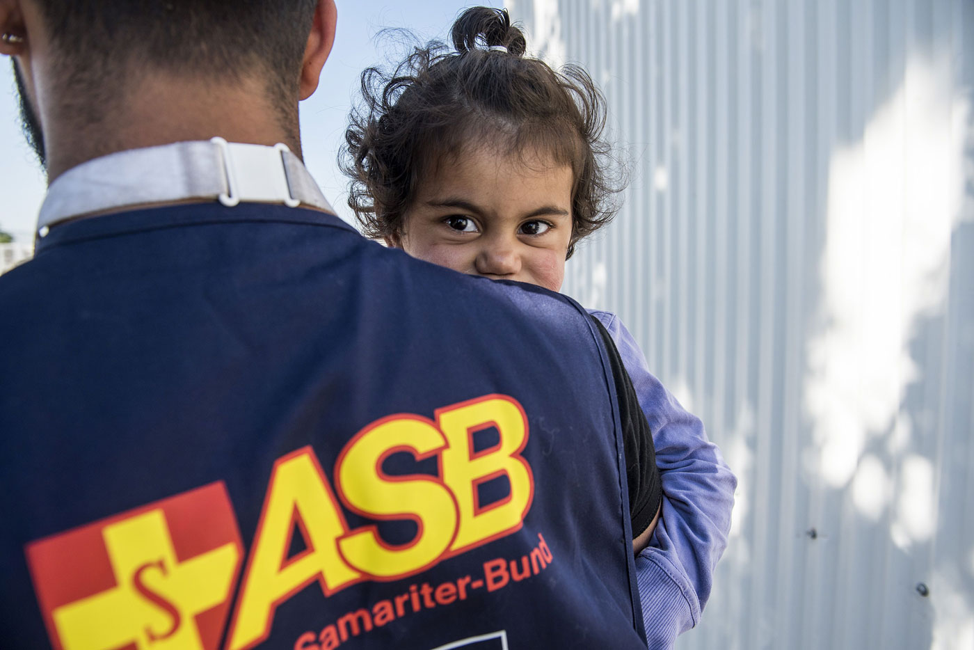 Samariter vom ASB trägt kleines Kind