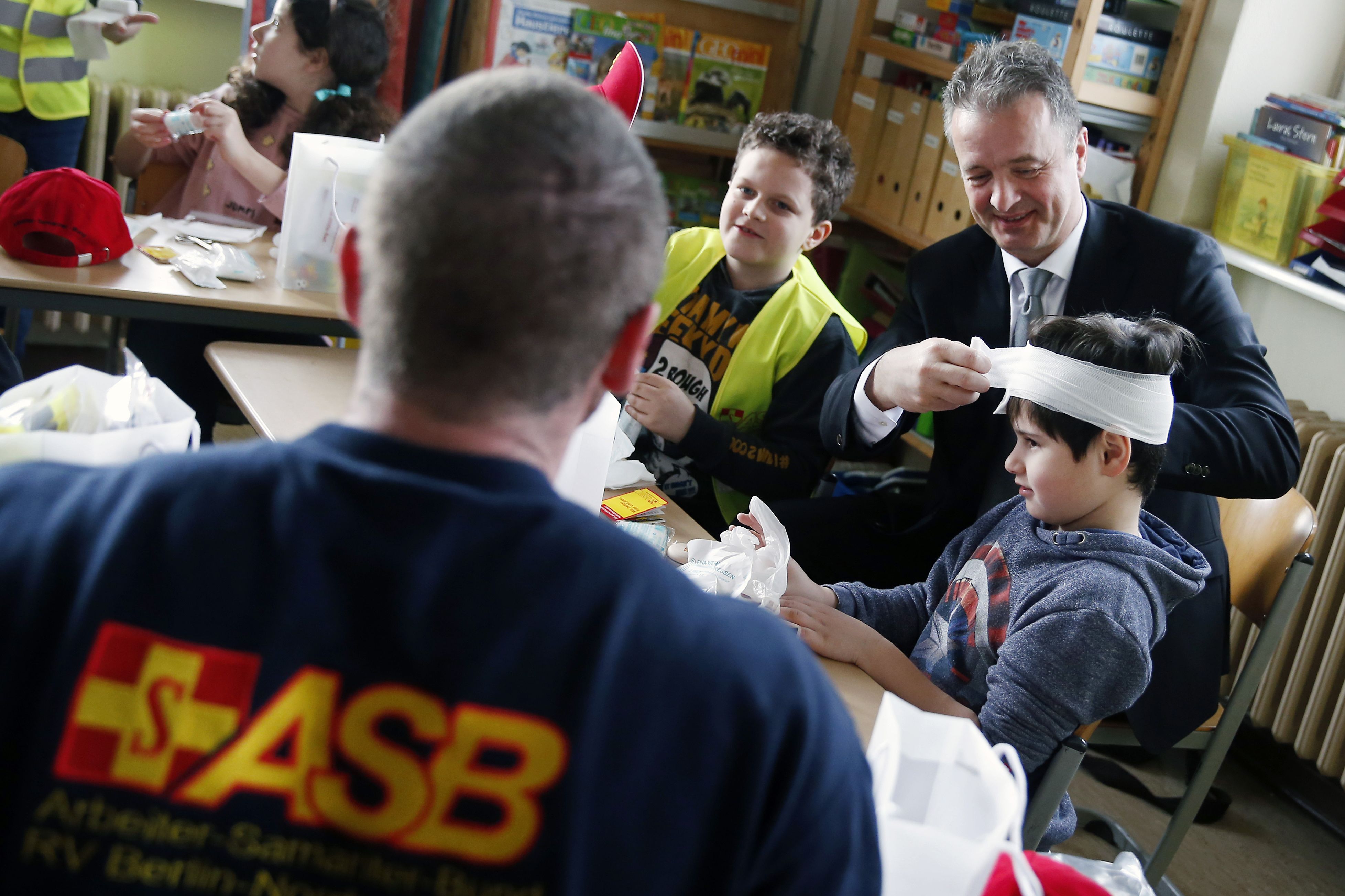 Erste Hilfe rettet Leben und ist kinderleicht zu lernen. Gemeinsam mit den Schülern der 4. Klasse übt ASB-Bundesgeschäftsführer Ulrich Bauch (re.) das Anlegen von Verbänden.