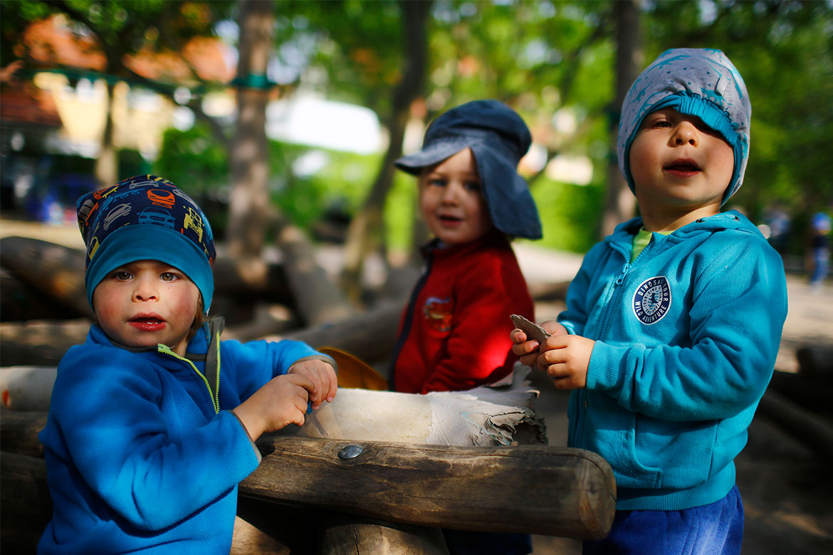 kindergarten-kinder-lugen-aus-einem-regal-hervor