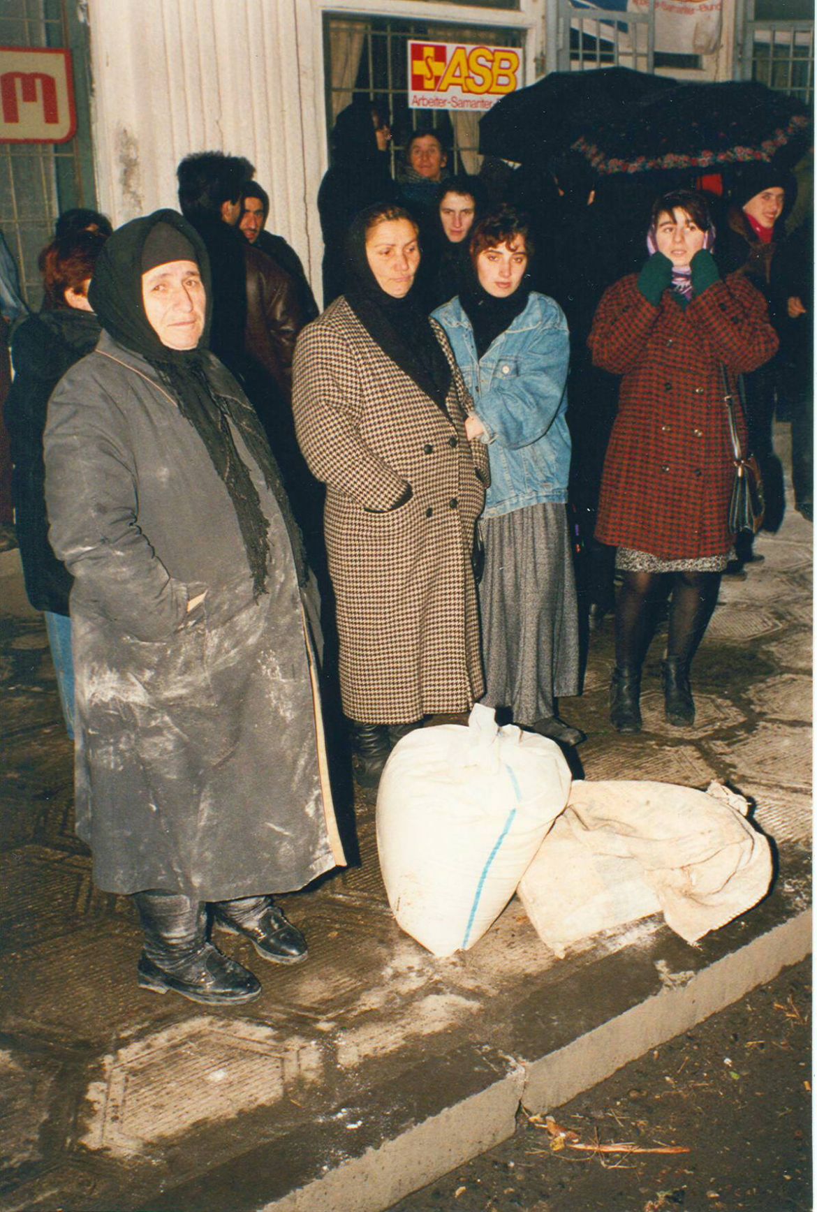 Hilfsbedürftige Menschen warten vor einer Verteilungsstelle für Nahrungsmittel. (Winter 1996)