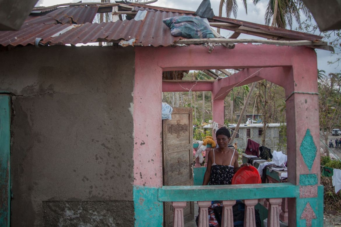 Junge Frau vor Hütte mit Schäden in Les Cayes in Haiti